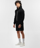 Side angle of Falcon black hoodie showing white front lettering and ribbed hem