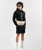 Falcon black hoodie styled with black shorts, white sneakers and a cream crossbody bag