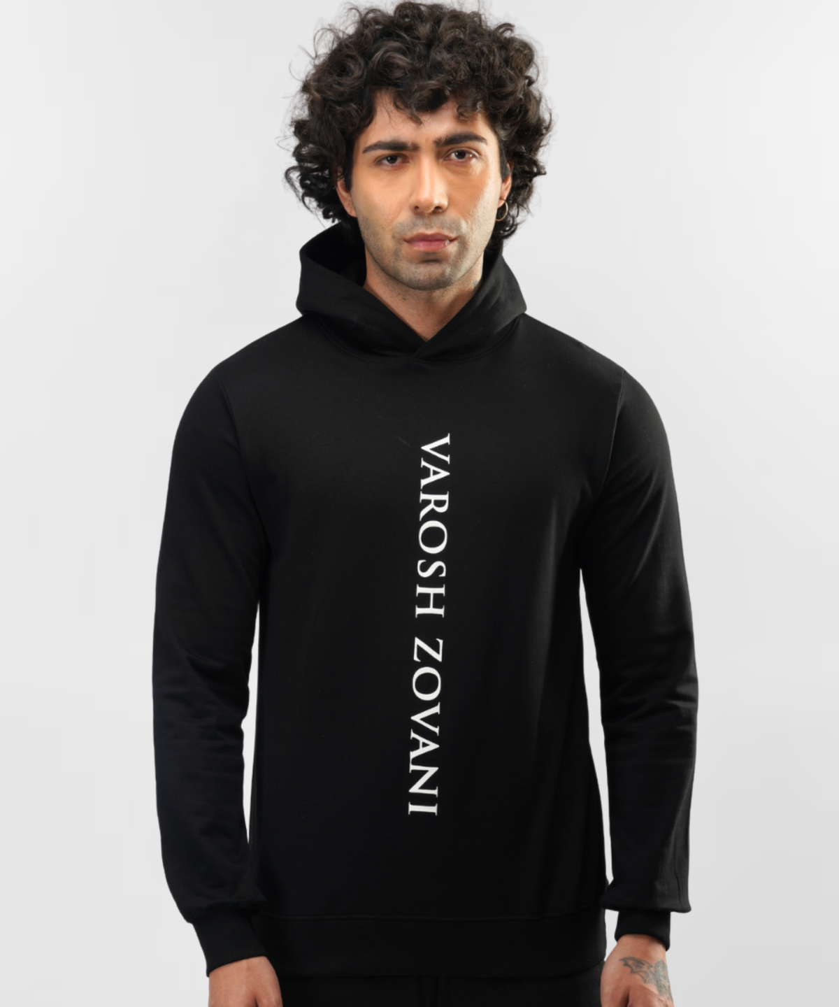 Model wearing Falcon black hoodie, close front view of vertical white lettering